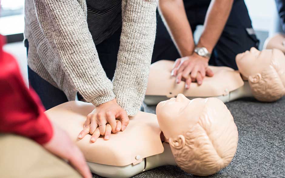 People performing CPR on training mannequins.