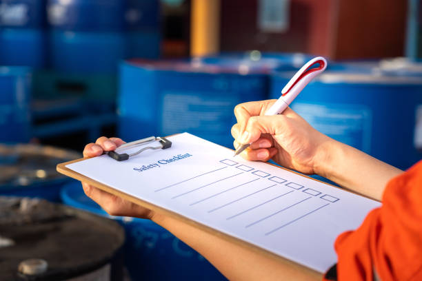 Worker checking a safety checklist in an industrial setting