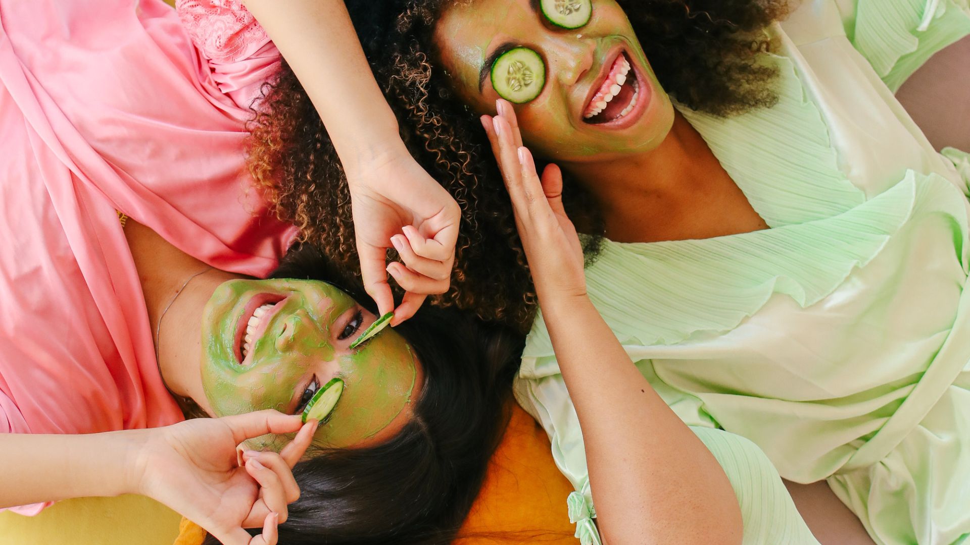 Two teens in pajamas with facemasks laughing